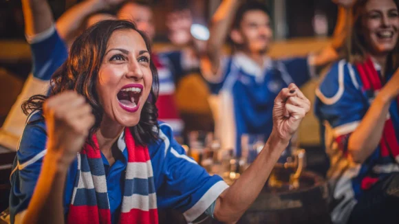 Football fans celebrating a goal watching the Champions League live at a pub in Holborn, central London