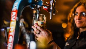 Bar staff pouring a draught beer at The Hercules Pillars, a traditional pub near Holborn station, London