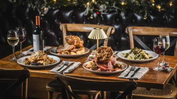 A festive table set with Christmas roast dishes and wine at St Christopher's Pub, Borough High Street, London Bridge