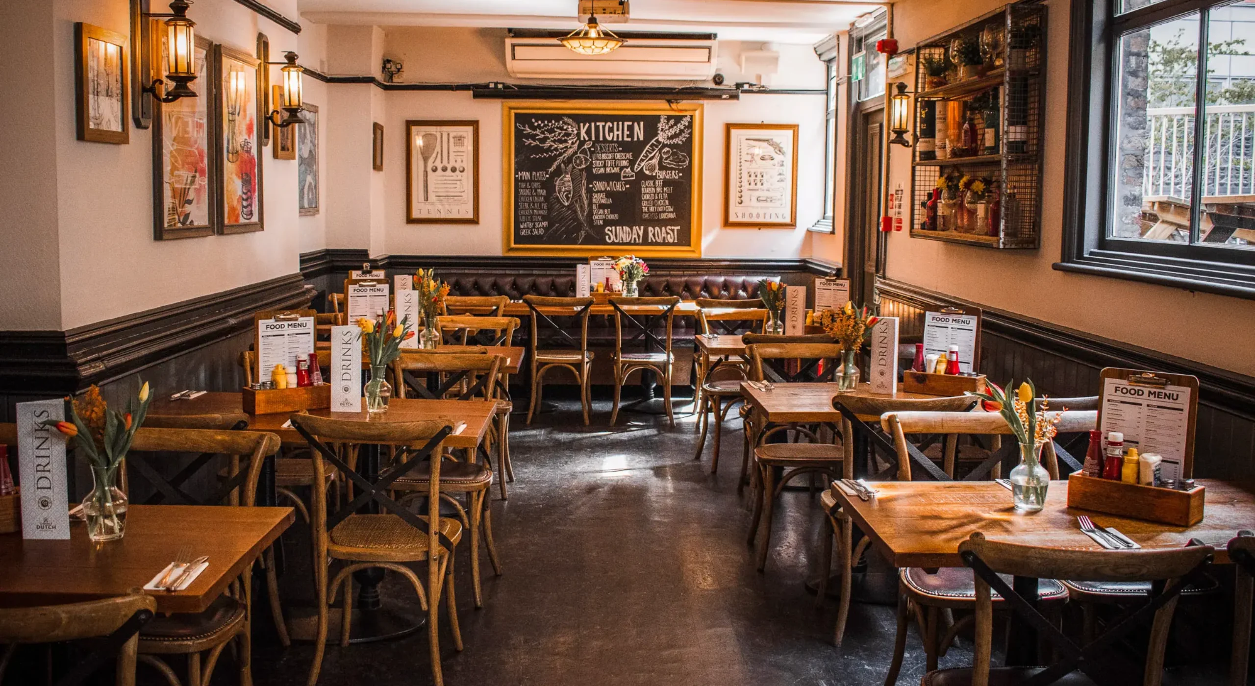 The dining room interior of St Christopher's Pub on Borough High Street, London Bridge, with wooden tables and chalkboard menu