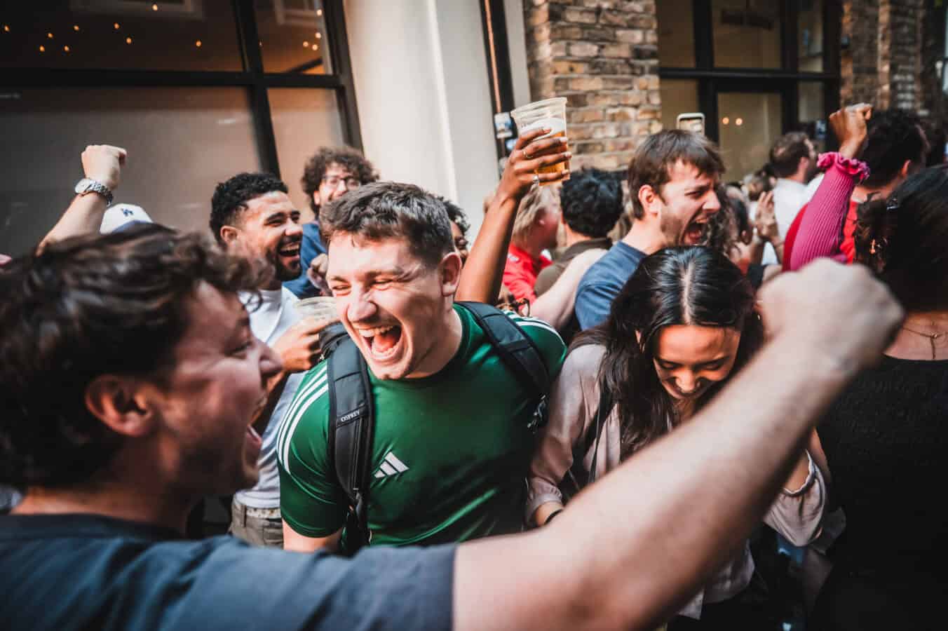 A crowd of people celebrating outside St Christopher's Pub on Borough High Street, London Bridge