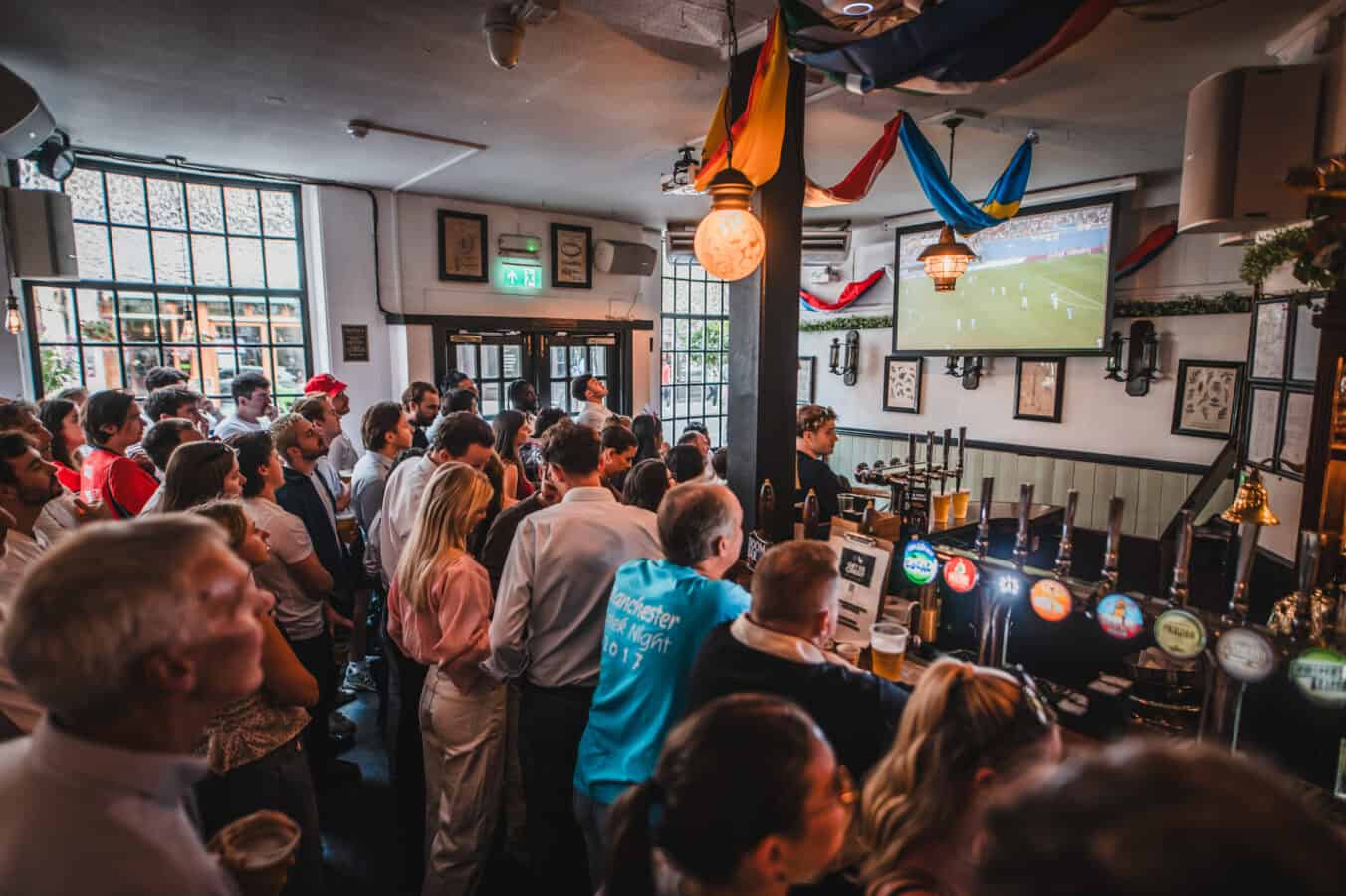 A packed interior at St Christopher's Pub London Bridge with fans watching live sport on a large projector screen